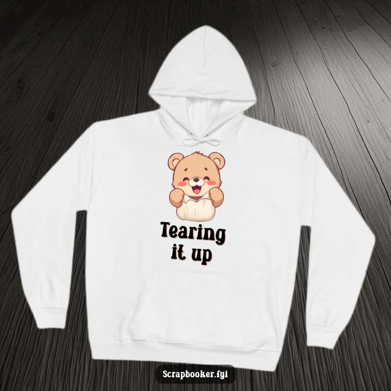 Funny hoodie featuring a happy bear cub excitedly ripping colorful paper with its paws, radiating joy.